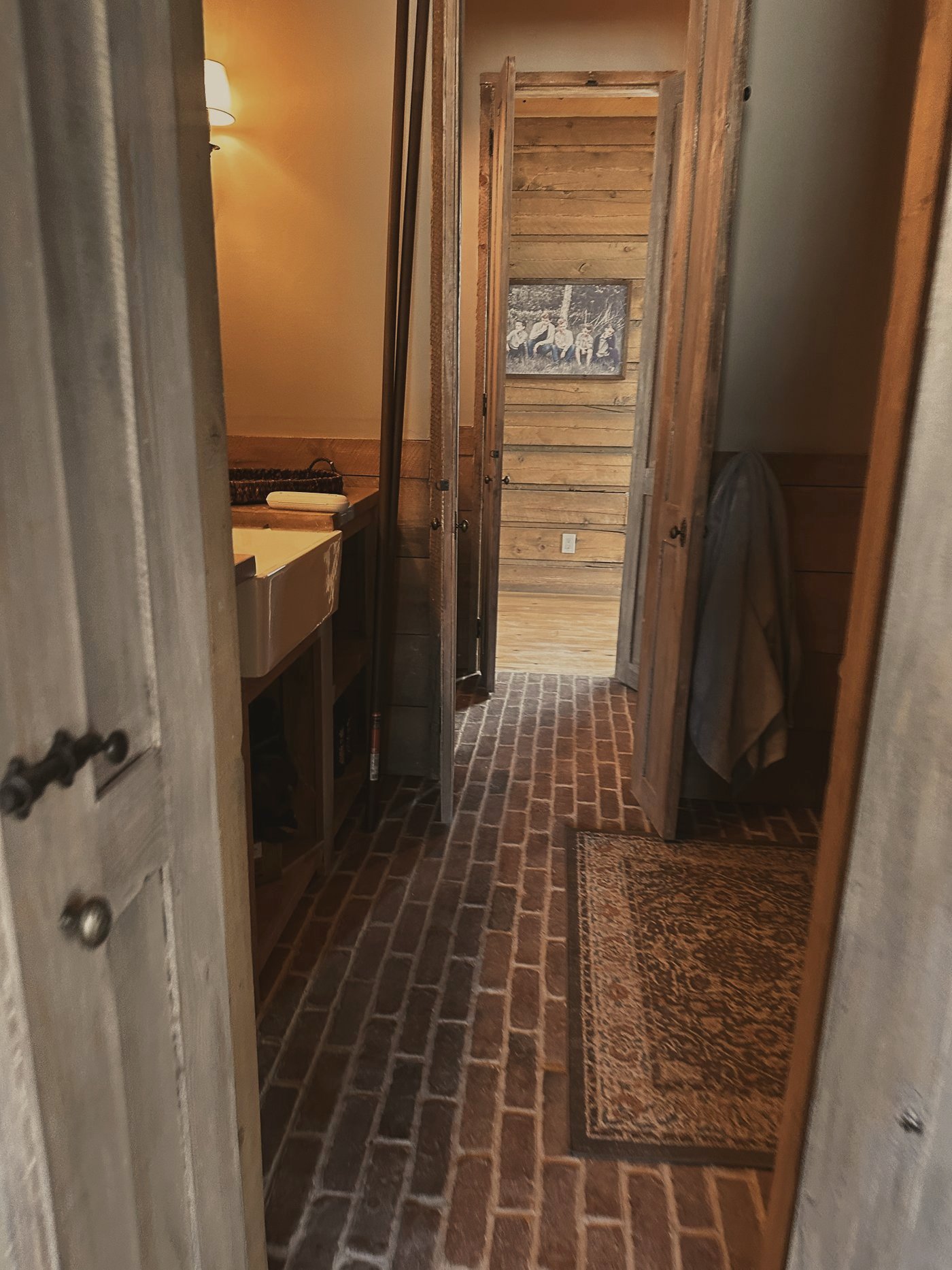 A brick-floored hall through rustic doors