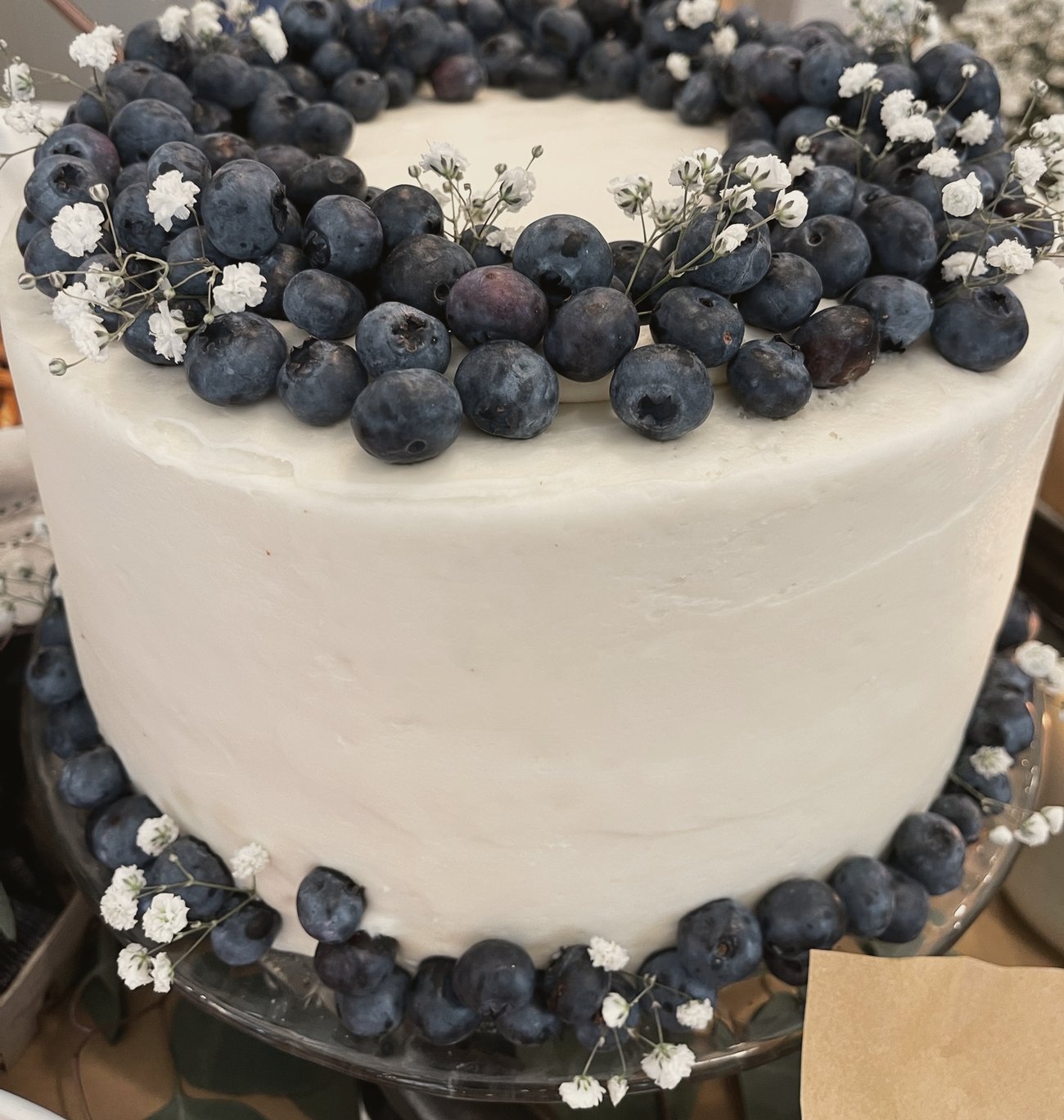 A white cake ringed with blueberries and baby’s breath