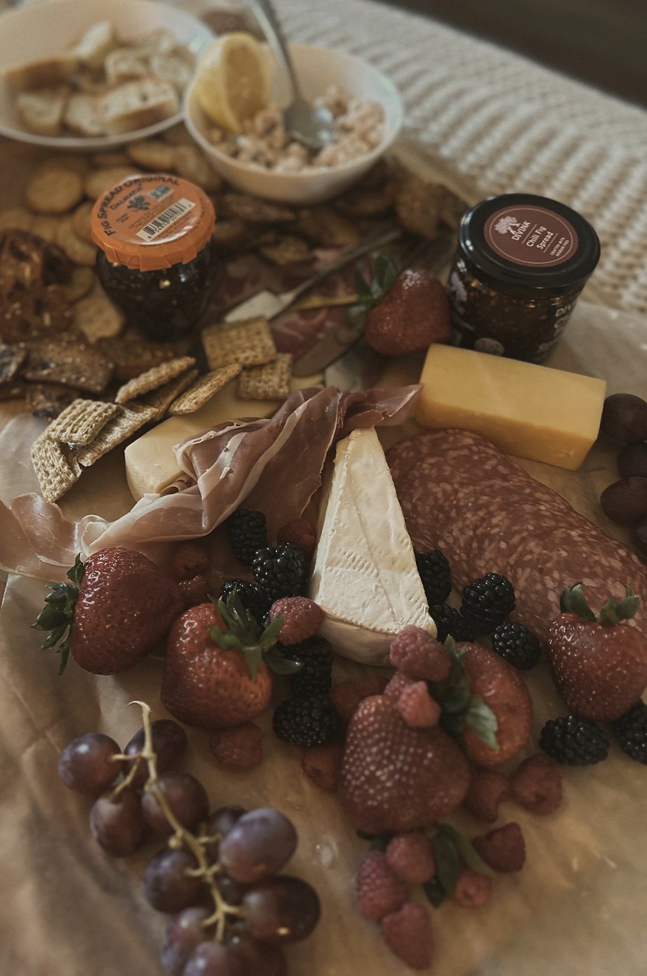 A knit blanket under a charcuterie spread