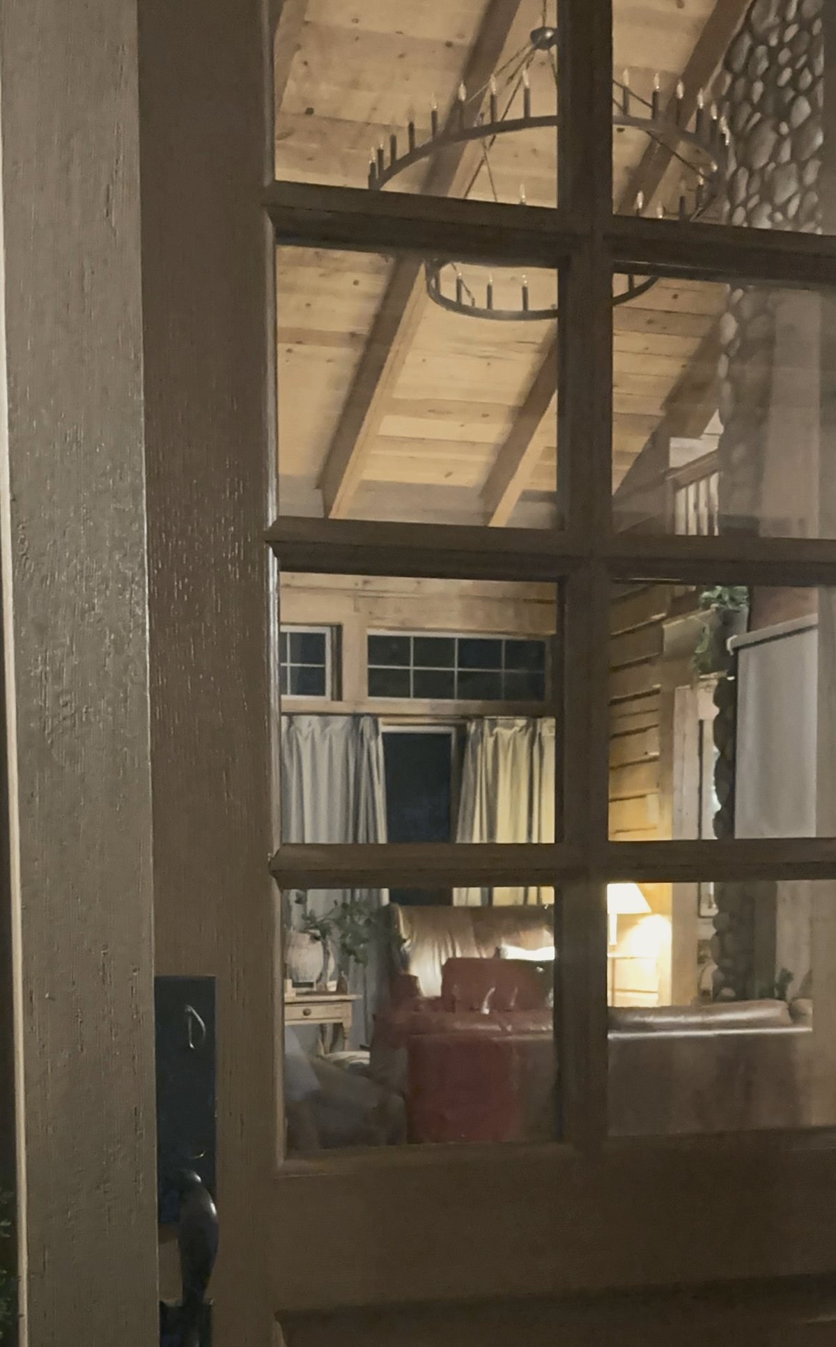 The great room glowing through the glass of our front door at night