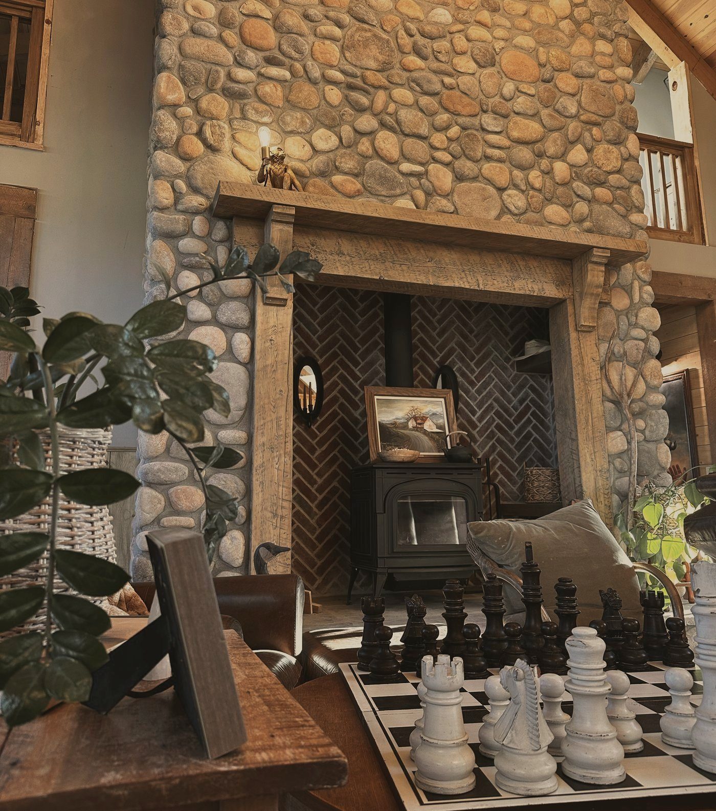 A giant chess set in front of the stone fireplace