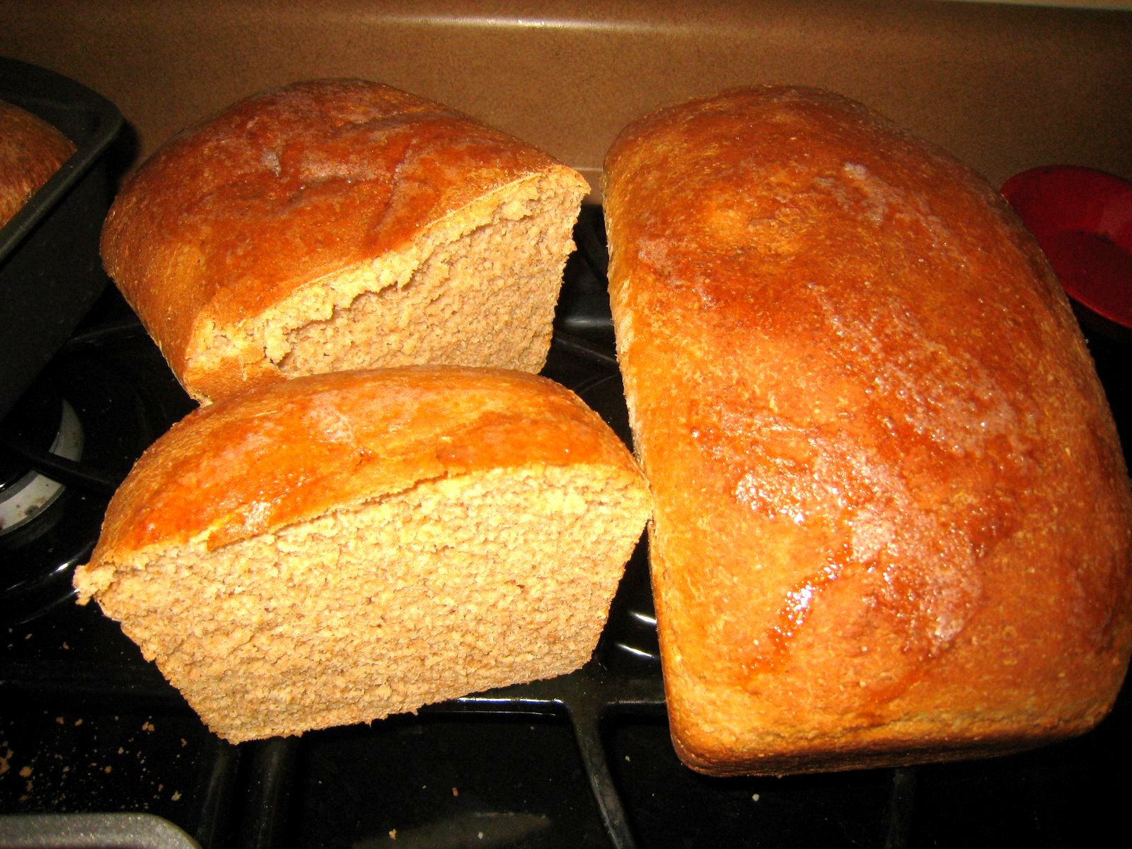 Golden homemade honey bread loaves, one sliced open