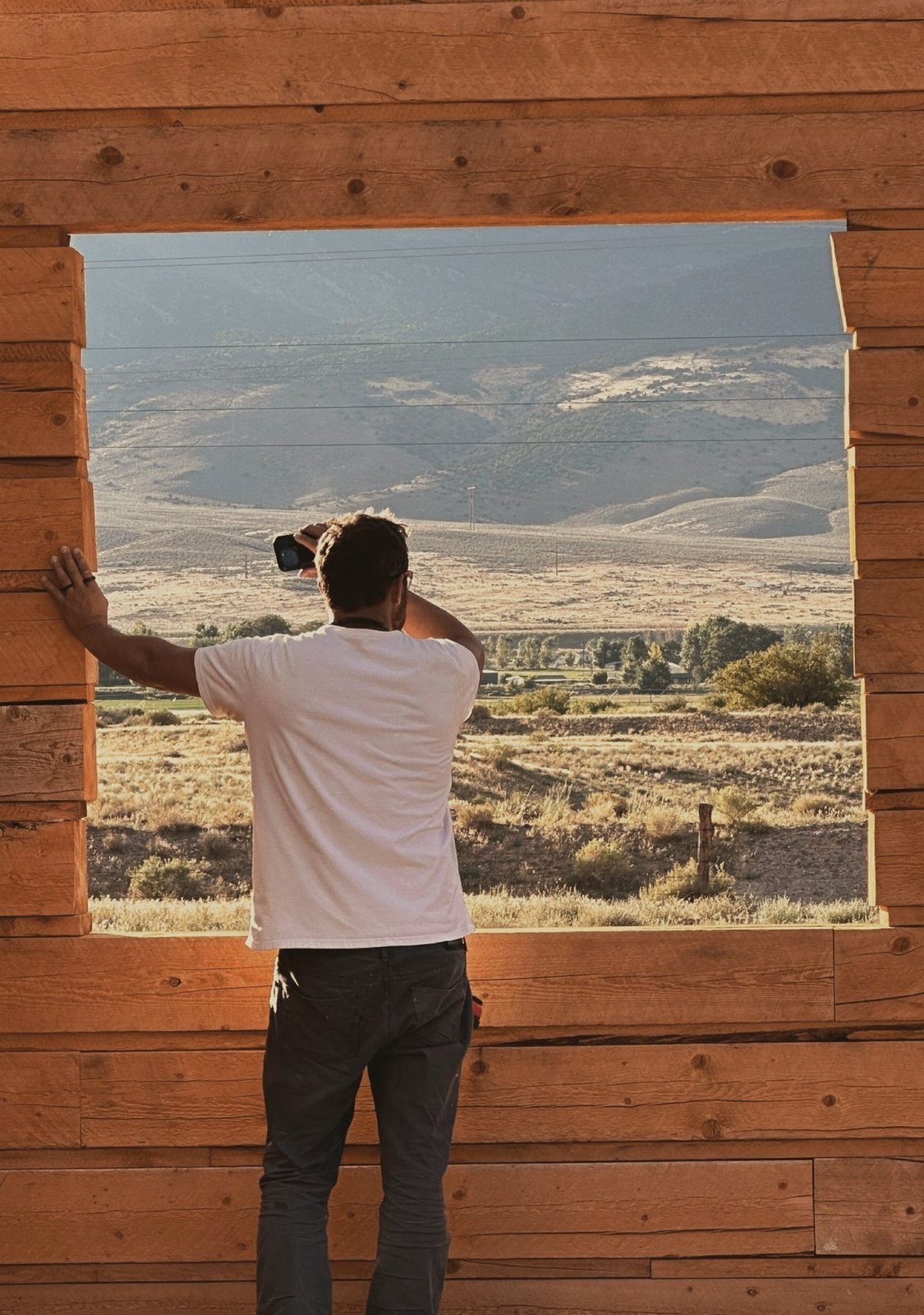 Looking out at the valley through a window opening in the log wall